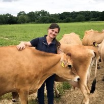 Sarah Bolton standing with some cows